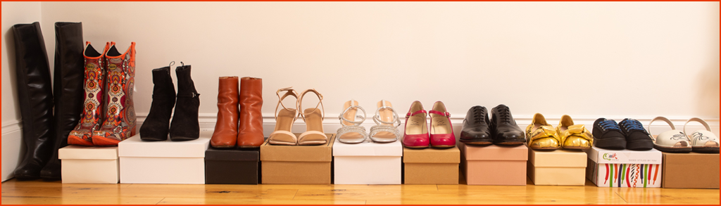 A line of shoes lined up on top of shoe boxes ready to be photographed